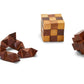 The Turf Club Wood Crafted Puzzles by Two's Company features three acacia wood puzzles: a solved cube, a star-shaped piece, and a disassembled set on a white background, each offering its own brain teaser challenge for your visual-spatial skills.