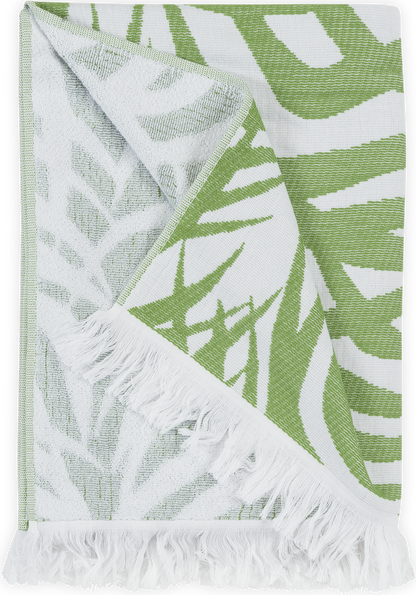 The Matouk Zebra Palm Beach Towel, Jungle features a green and white tropical leaves design, cotton terry texture, and white fringe edges.