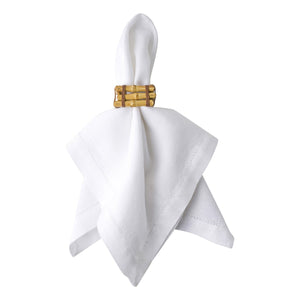 A white cloth napkin is elegantly held by the Juliska Bamboo Napkin Ring, shown against a white background—a stylish and versatile accent for any table setting.