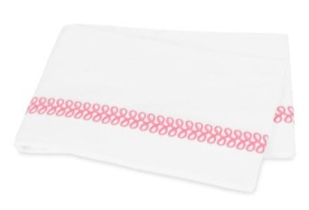 The Matouk Astor Braid Bedding Collection in Peony features luxurious white Ceylon percale with a horizontal pink embroidered braid near the edge.