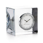 The Woodbury Clock by Simon Pearce features a square glass design with a round white face and silver rim, displaying 10:11—a timeless gift for any occasion.