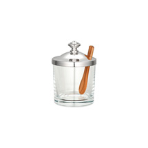 The Christofle Albi Silver Plated Mustard/Jam Pot features clear glass, a silver lid, and a wooden spoon inside, displayed against a plain white background.