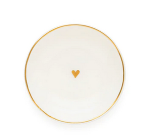 The Sugar Paper Small Round Heart Trinket Tray features a white surface, a gold rim, and a small gold heart in the center.
