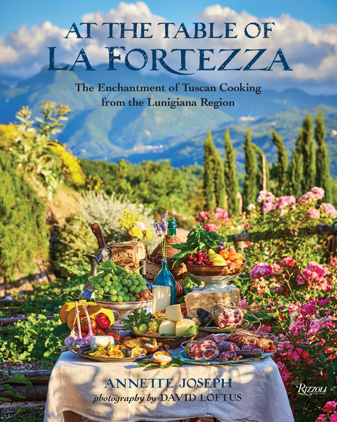 An outdoor At the Table of La Fortezza feast showcasing regional cuisine amidst a picturesque landscape.