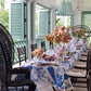 A table set on a porch with green shutters inspired by island living and Common Ground's Island Hopping interiors.