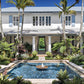 Luxurious two-story blue and white colonial house in Beachside: Windsor Vero Beach with a central fountain pool surrounded by lush tropical landscaping by Common Ground.