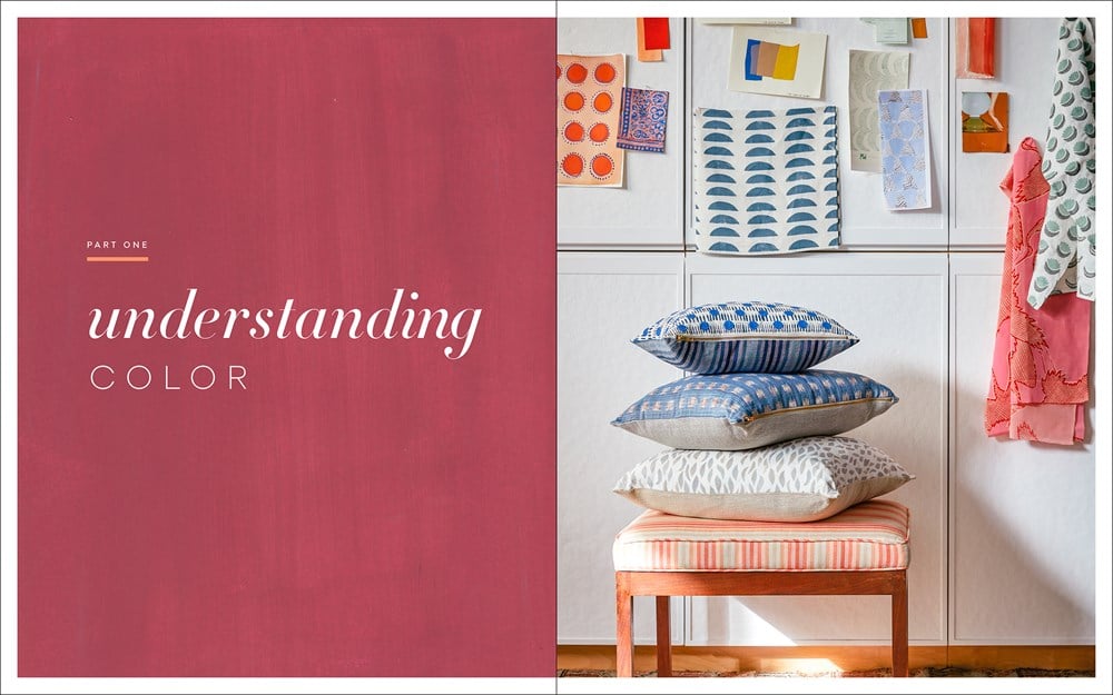 A stack of patterned pillows sits on a bench before a wall of colorful swatches, showcasing vibrant hues; text reads "Living with Color" by Penguin Random House.