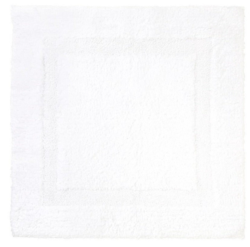 The Yves Delorme Aquilon Bathmat in Blanc is a square, white cotton mat with a subtle border design, adding elegance to any bathroom. This versatile and reversible mat offers both style and practicality.