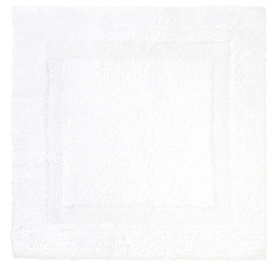 The Yves Delorme Aquilon Bathmat in Blanc is a square, white cotton mat with a subtle border design, adding elegance to any bathroom. This versatile and reversible mat offers both style and practicality.