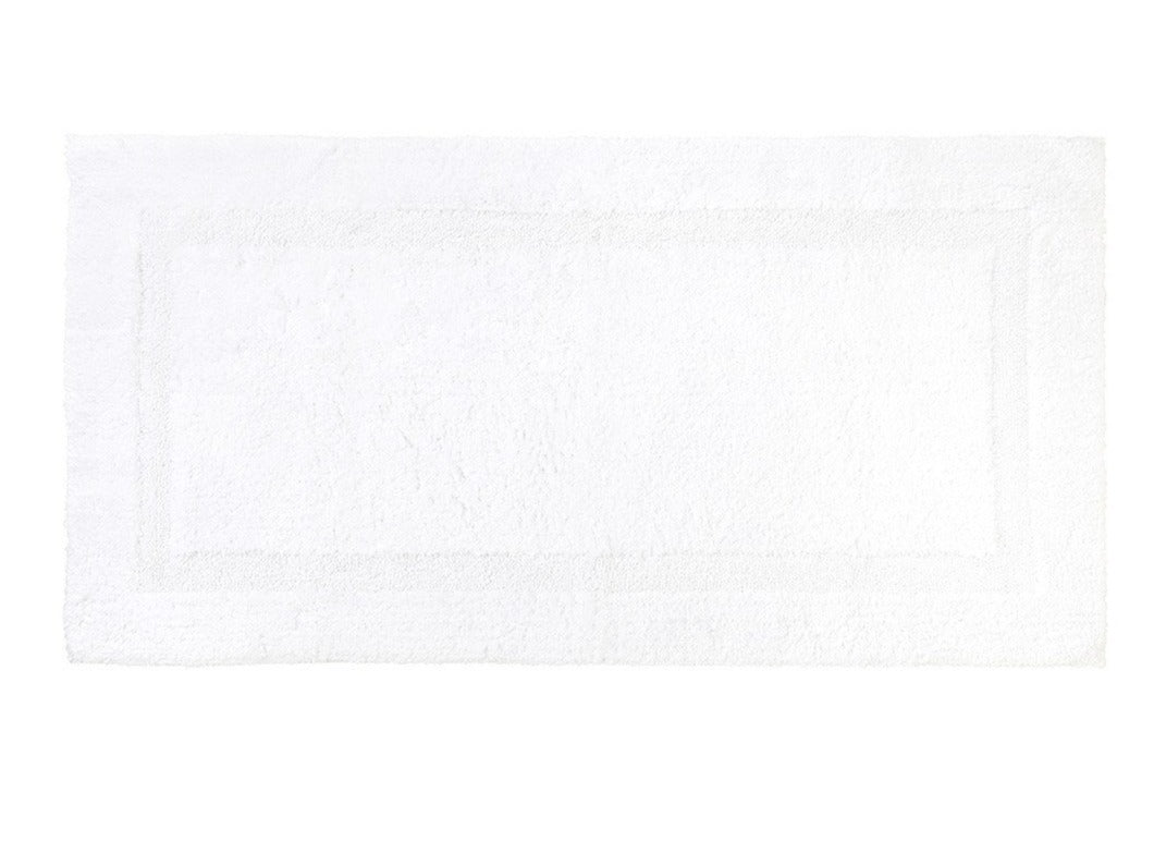 The Yves Delorme Aquilon Bathmat Collection, Blanc is a reversible rectangular cotton bath rug with a textured border design, by Yves Delorme.