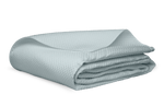 A folded light gray blanket from the Matouk Alba Bedding Collection, Pool, made of luxurious Egyptian cotton sateen, is displayed on a white surface.