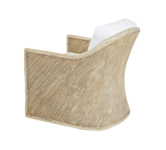 Showcasing a rattan frame, the Almario Lounge Chair by PALECEK is elegantly composed with a woven beige design and white cushion, captured in a side angle against a crisp white background.