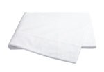 A Matouk Ansonia white cotton percale sheet draped over a black background, exuding luxury.
