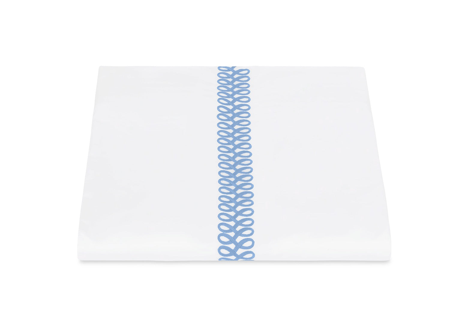 A neatly folded white sheet from Matouk’s Astor Braid Bedding Collection, Sky, crafted from Ceylon percale and featuring a single vertical blue embroidered Astor Braid down the center.