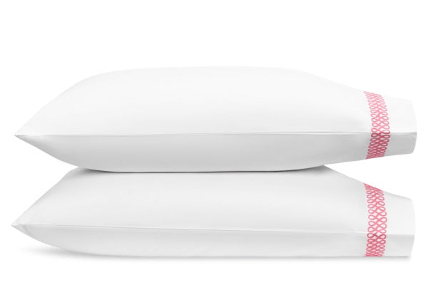 Two white pillows from the Matouk Astor Braid Bedding Collection in Peony, stacked together, each featuring a pink embroidered edge.