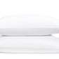 Two white pillows from Matouk’s Astor Braid Bedding Collection in Sky, each featuring a blue geometric embroidered edge, crafted from luxurious Ceylon percale.
