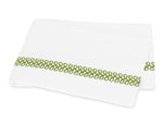 An embroidered Matouk Astor Braid Bedding Collection, Grass sheet with green trim, made from Ceylon percale fabric.