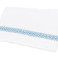White towel with a decorative blue Matouk Astor Braid pattern along one edge, displayed on a plain background.