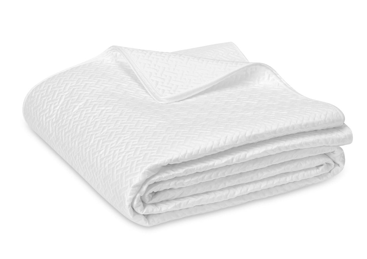 A neatly folded Matouk Basketweave Bedding Collection, White with a subtle woven pattern in a diamond design, crafted from luxurious Egyptian cotton sateen.
