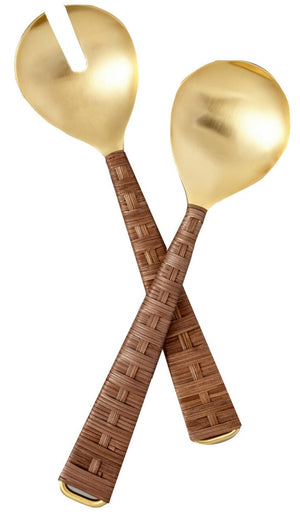 The Ananta Serving Set by Be Home is a handcrafted 2-piece set from India, featuring gold-toned serving utensils with woven brown handles—one slotted spoon and one solid spoon—displayed on a white background.
