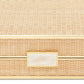 A close-up of the Aerin Cane Backgammon Set, a rectangular woven rattan box featuring brass hardware and a gold-trimmed ivory handle on the front.
