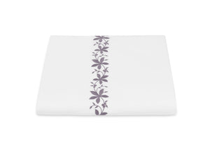 White square dinner plate with a Matouk Callista Bedding Collection, Lilac design running down the center, isolated on a white background.