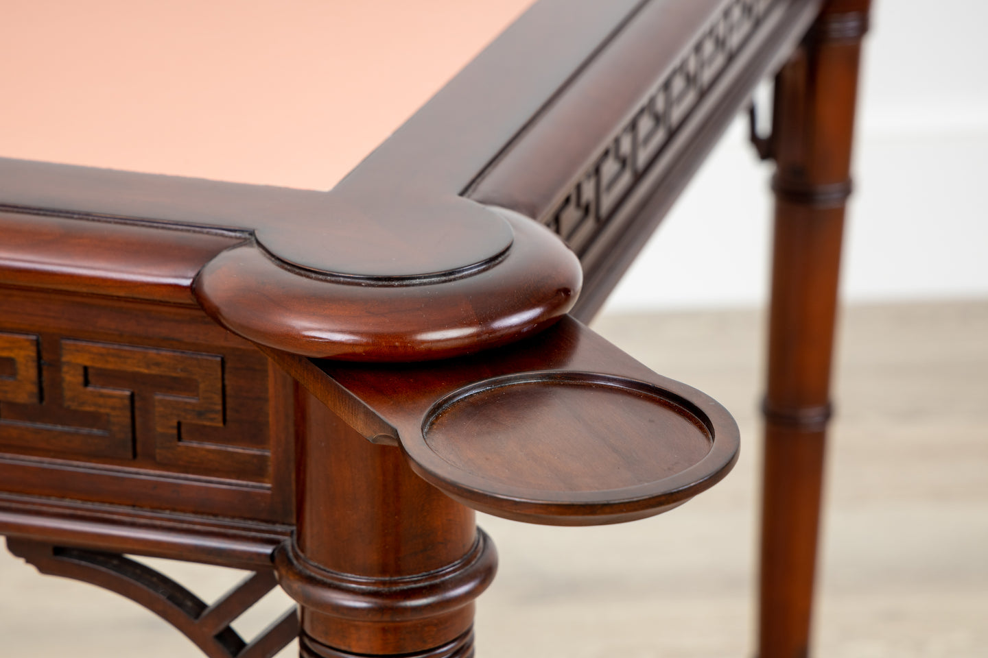 A Kindel Card Table with Pink Leather and a carved top.