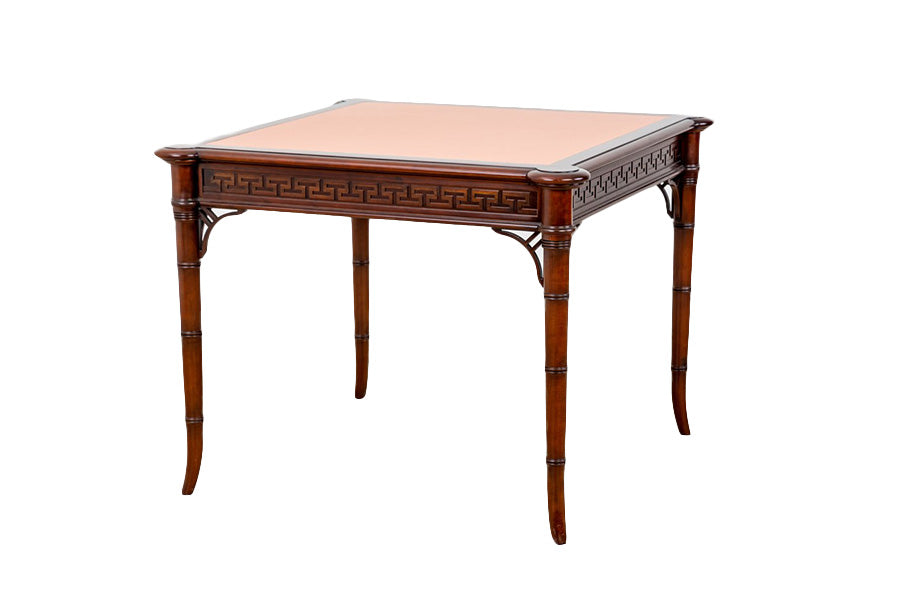 A small Kindel wooden table with a pink leather top featuring a Greek key design.