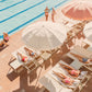 People enjoying poolside glamour on sun loungers by a swimming pool under parasols at the Gray Malin Coral Casino Beach & Cabana Club, White Frame, 15.5” X 21”.