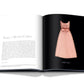 An open book displays text on the left page and a photo of a pink sleeveless dress on the right. The dress, reminiscent of haute couture, features a ribbon at the waist and a textured upper section, making it one of those fashion treasures you'll adore. Titled "Dior III by Marc Bohan" by Assouline, this book captures the essence of timeless elegance.