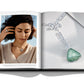 An open book reveals a woman wearing a necklace on the left page and a detailed image of a gemstone necklace on the right, capturing the elegance that Assouline exemplifies with their luxury designs and natural diamonds in "Diamonds: Diamond Stories".