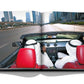 Two individuals in traditional attire are driving a car with red seats on an urban highway, detailed beautifully in the pages of Dubai Wonder by Assouline. Skyscrapers line the road in the background, showcasing the cultural diversity typical of Dubai tours.