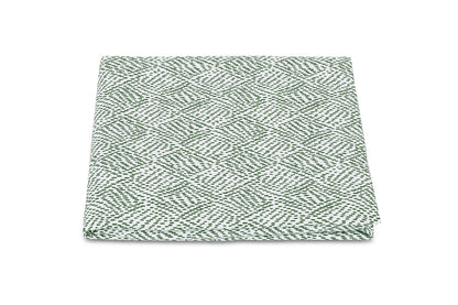 The Matouk Duma Diamond Bedding Collection quilt features a harlequin pattern in green and white, crafted from luxurious Egyptian cotton percale on a pristine white background.