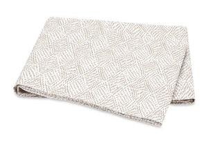 The Matouk Duma Diamond Bedding Collection in Dune features OEKO-TEX® certified Egyptian cotton percale with a subtle harlequin pattern on a light, white background.
