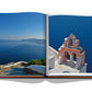 Open book displaying a photograph of a traditional Santorini church, embodying Greek hospitality and overlooking the Aegean Sea from Assouline's Greek Islands.