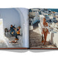 An open book showcasing a vibrant Greek island scene by the Aegean Sea with a guitarist and a woman enjoying the sunny atmosphere and Greek hospitality from Assouline's "Greek Islands.