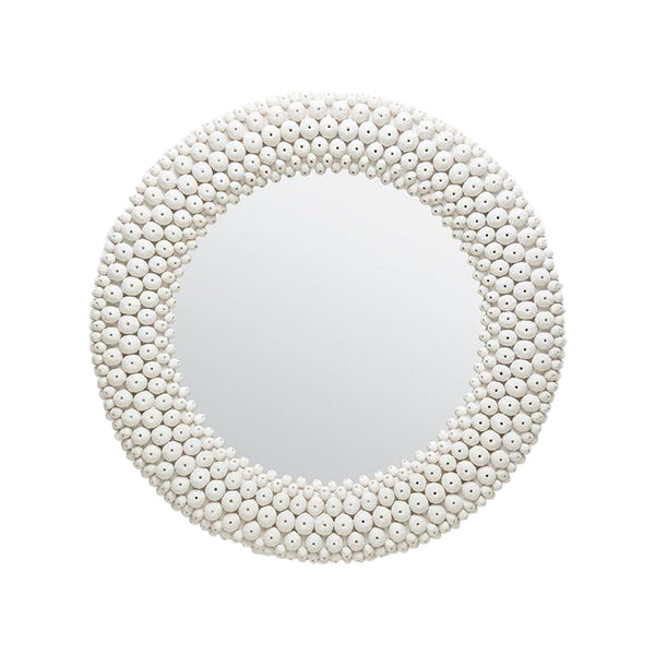 A round mirror adorned with delicate white beads and earthy resin sea urchin shells, inspired by the beautiful coastal artwork of Made Goods' Helene Coral White Sea Urchin Round Mirror.