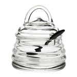 The William Yeoward Crystal Honeybee Honey Jar and Spoon features a beehive-inspired clear glass jar with matching lid and black spoon. Proposition 65 warning applies.