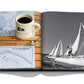A Hamptons Private book from Assouline with a picture of sailboats and a cup of coffee.