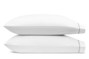 Two white pillows from the Matouk Hatch Bedding Collection in Oak stacked horizontally, featuring edge stitching on the bottom pillow, crafted from Ceylon percale and OEKO-TEX® Standard 100 certified for premium comfort.
