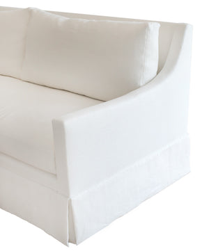 A Hannah Sofa by Verellen, with a ruffled skirt, featuring upholstery.