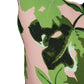 Close-up of the Pink Fig Leaf Outdoor Pillow by Hive Custom Pillows, handmade in the USA with a green leaf pattern on light pink and green braided piping along the edge.
