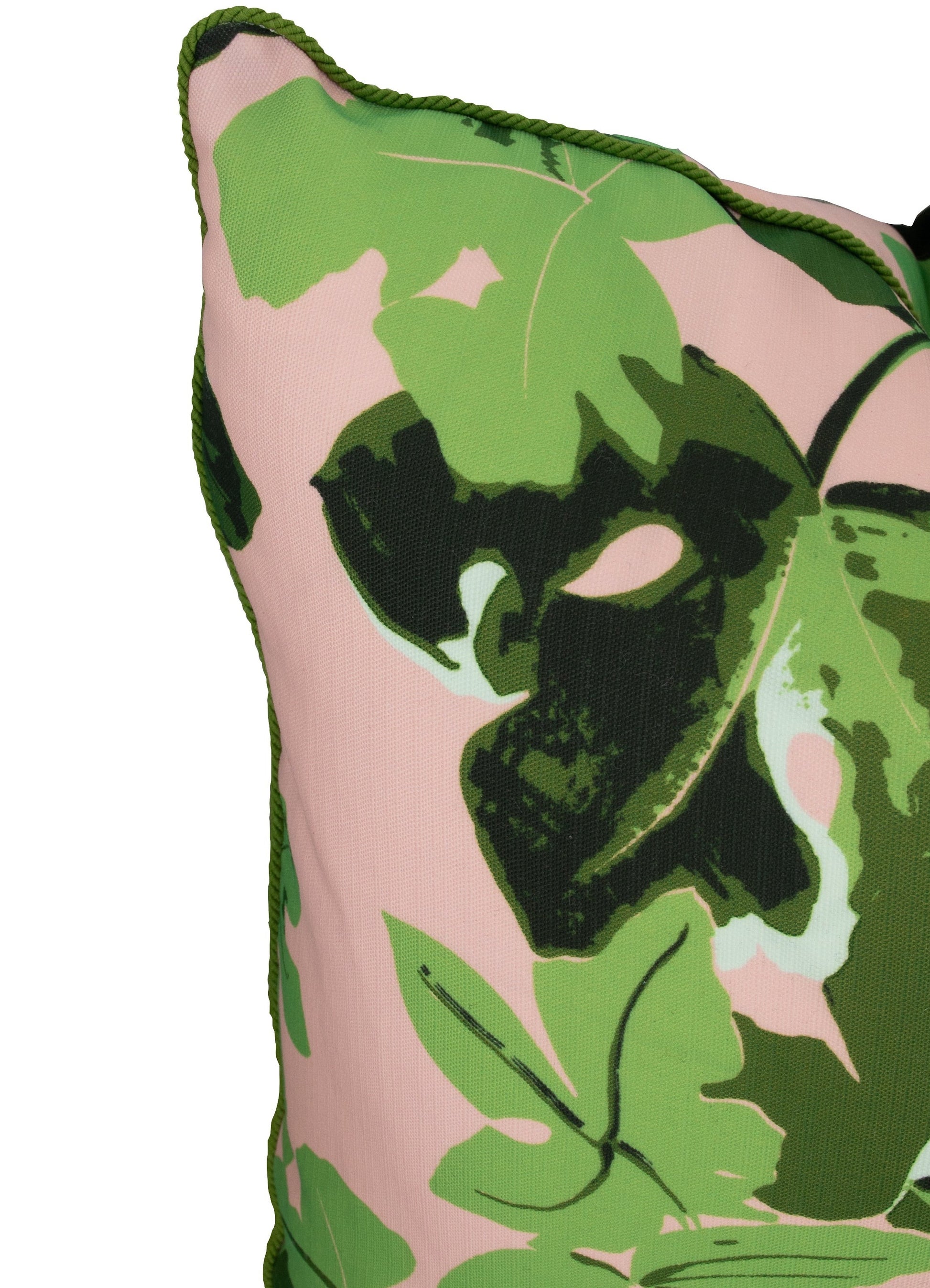 Close-up of the Pink Fig Leaf Outdoor Pillow by Hive Custom Pillows, handmade in the USA with a green leaf pattern on light pink and green braided piping along the edge.