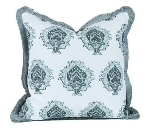 The Artichoke in Bay Pillow by Hive Custom Pillows features a square shape, white background, blue-green patterned design, and fringed trim.