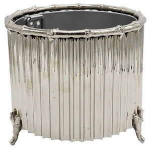 The Small Nickel Corrugated Bamboo Cachepot by Global Views is a handmade, metallic cylindrical piece with vertical ridges, bamboo-inspired edges, and four petite feet.