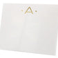 The Gold Initial Large Notepad by Black Ink features a white rectangular box with a gold letter "A" and two gold dots on the front, crafted from high-quality heavy weight paper.
