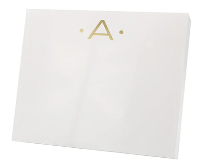 The Gold Initial Large Notepad by Black Ink features a white rectangular box with a gold letter "A" and two gold dots on the front, crafted from high-quality heavy weight paper.