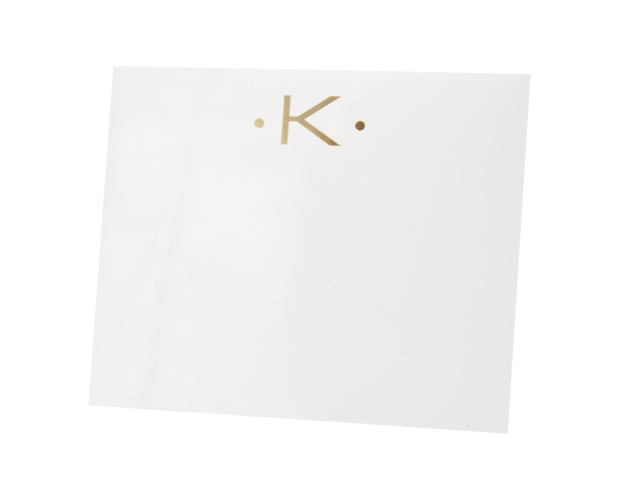 The Gold Initial Large Notepad by Black Ink features a gold letter "K" centered near the top of its heavy weight white square pages, accented by two gold dots.