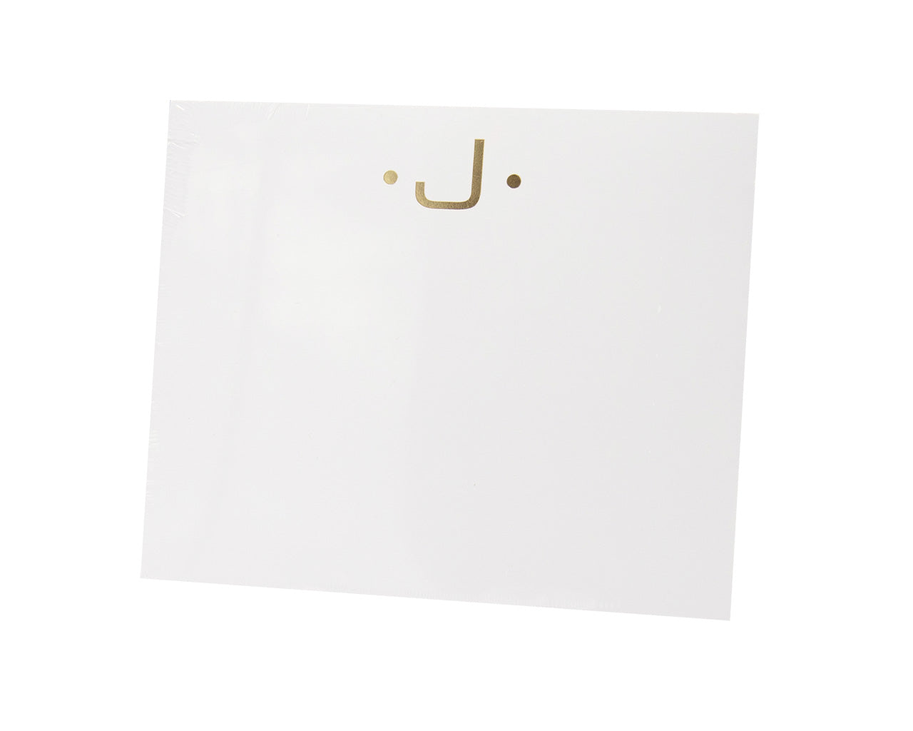 The Gold Initial Large Notepad by Black Ink features heavyweight white paper with a central minimalist gold smiley face—two dot eyes and a curved line for the mouth.
