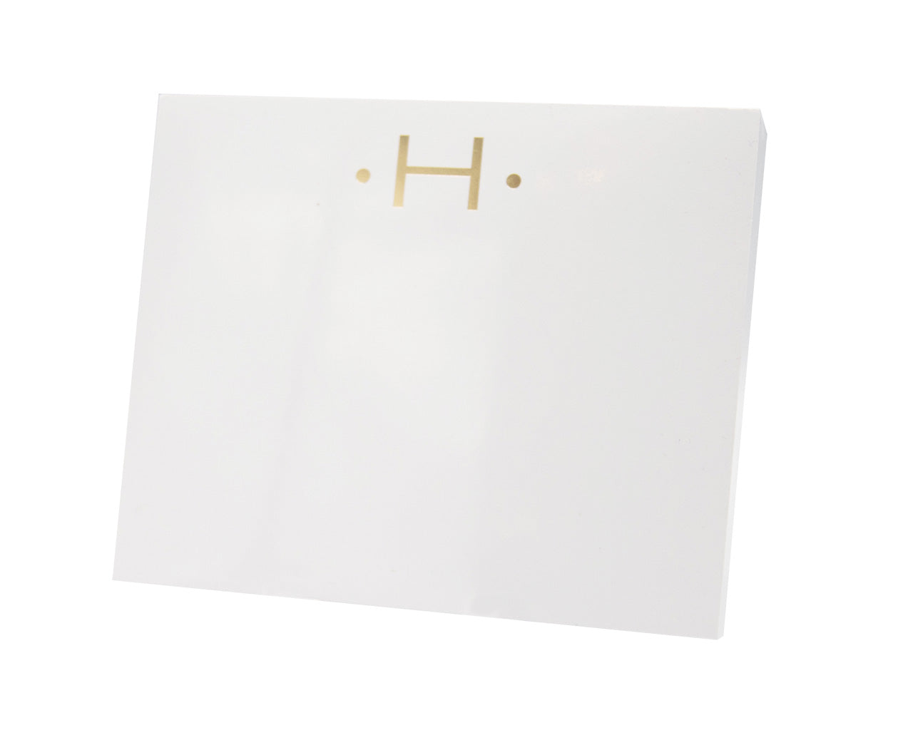The Gold Initial Large Notepad by Black Ink comes in a white square box made of heavy weight paper, featuring a minimalist gold letter "H" and two gold dots on the front against a plain white background.